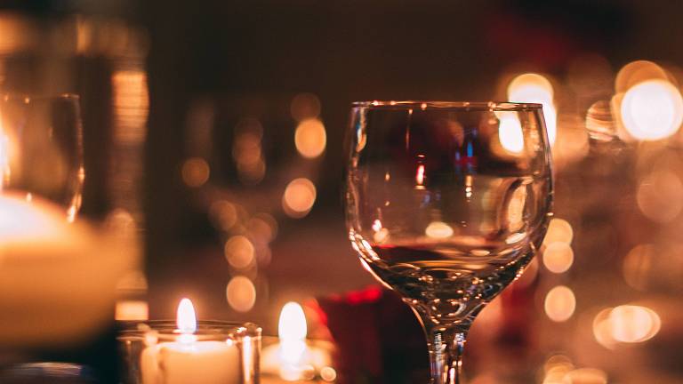 Kerzenschein und Weinglas bei Nacht